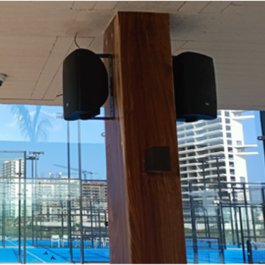 Un par de bocinas de exterior montadas en una columna para la distribución de audio ambiental en áreas comunes o recreativa