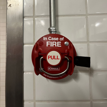 Estación de extracción manual (pull station) de la marca Ansul, utilizada para activar de forma mecánica el sistema de supresión de incendios en cocinas comerciales.