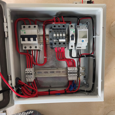 Interior de un gabinete o cuadro eléctrico con componentes de protección Schneider Electric, un contactor ABB y un temporizador/controlador digital perfectamente cableado.